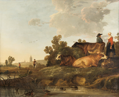 A drover and milkmaid standing beside cattle, a view to a town in the distance by Aelbert Cuyp