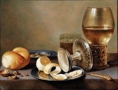 Monochrome Banketje with two pewter dishes, an overturned silver tazza, a gilt knife, a glass with beer, a rummer with wine, a roll of bread, nuts, olivers and a half peeled lemon by Hans van Sant