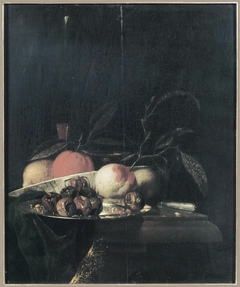 A lemon and orange in a porcelain bowl, a glass of wine, dates on a silver plate, an apple, a peach and a knife, all on a partially draped table by Juriaen van Streeck