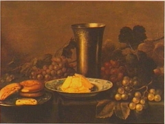 Still life of fruit with bread, butter and a silver cup by Floris van Schooten