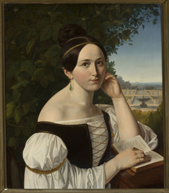 Portrait of a young woman with a book in a park by Anonymous