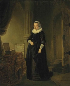 Portrait of a woman, standing full length in an interior by Rembrandt